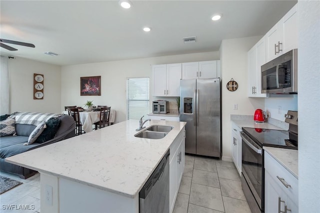 kitchen featuring sink, white cabinetry, light stone countertops, an island with sink, and stainless steel appliances