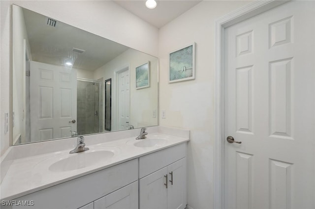 bathroom featuring a shower with door and vanity