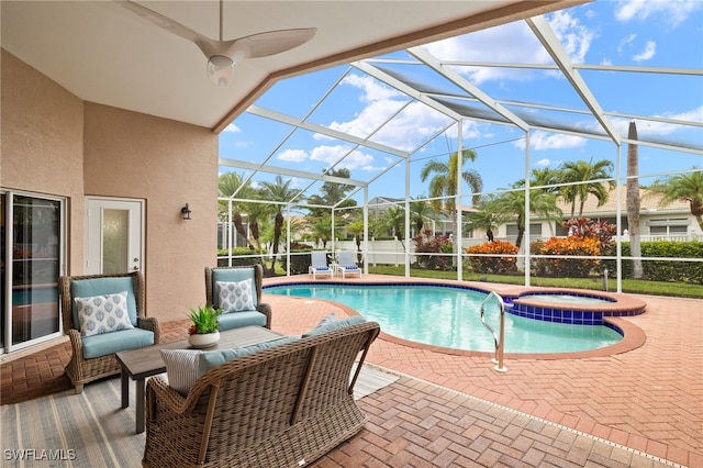 view of pool with glass enclosure, a patio area, and an in ground hot tub