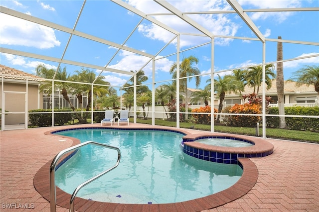 view of pool with a lanai, an in ground hot tub, and a patio