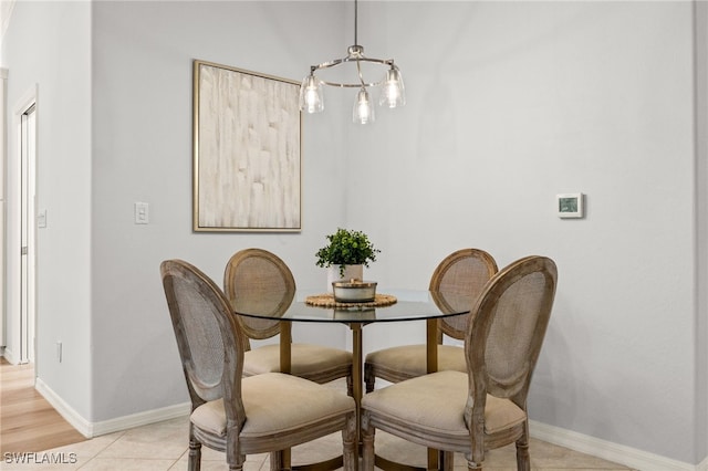 tiled dining space with a chandelier