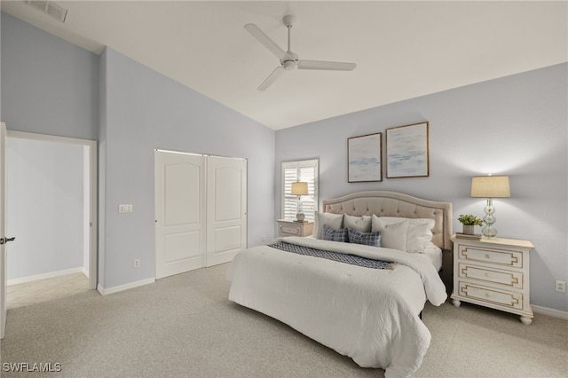 carpeted bedroom with ceiling fan, a closet, and high vaulted ceiling