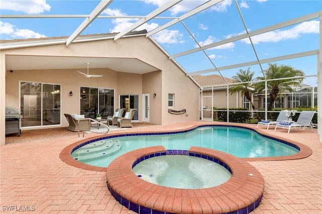 view of swimming pool featuring glass enclosure, a patio area, area for grilling, and an in ground hot tub