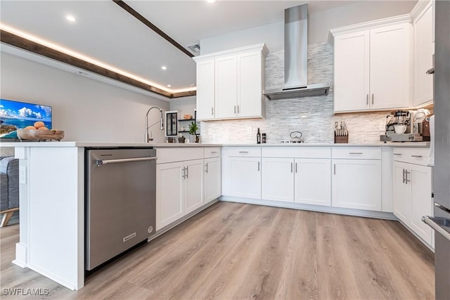 kitchen featuring light hardwood / wood-style floors, dishwasher, white cabinets, and wall chimney range hood