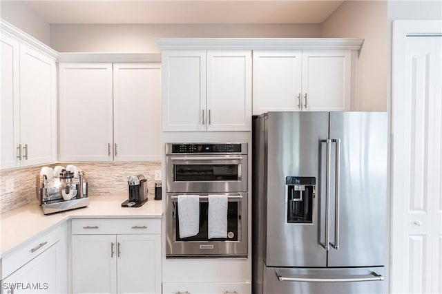 kitchen with tasteful backsplash, appliances with stainless steel finishes, and white cabinetry