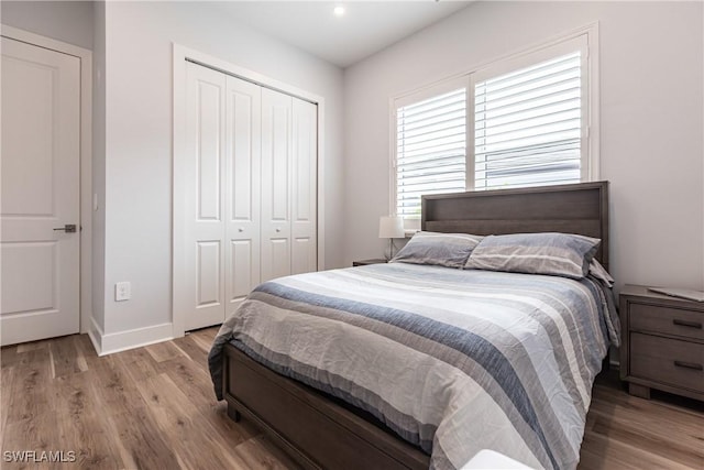 bedroom with light hardwood / wood-style floors and a closet