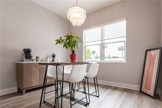 dining area featuring light wood-type flooring and a notable chandelier