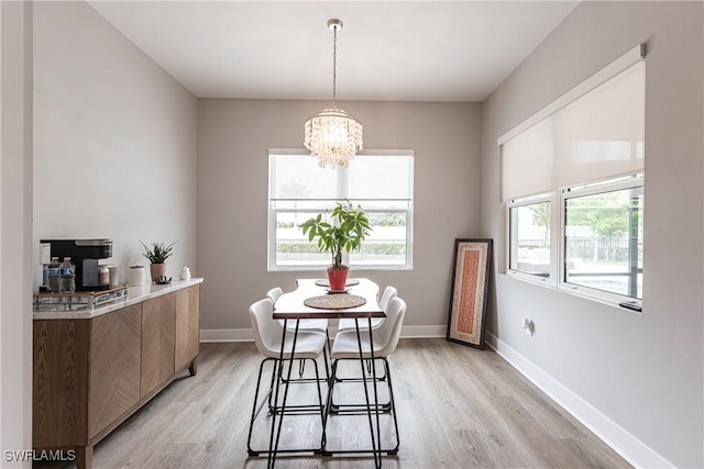 dining area featuring light hardwood / wood-style flooring and a notable chandelier