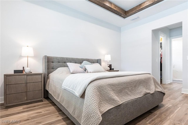 bedroom featuring light hardwood / wood-style floors and a raised ceiling