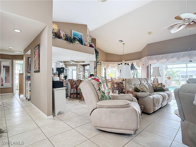 tiled living room with ceiling fan and high vaulted ceiling