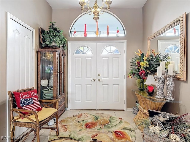 tiled foyer featuring a healthy amount of sunlight and a chandelier