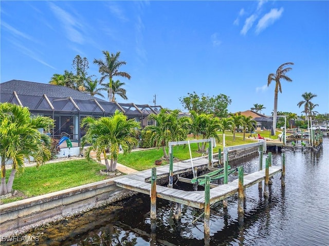 view of dock featuring a lanai, a water view, and a lawn