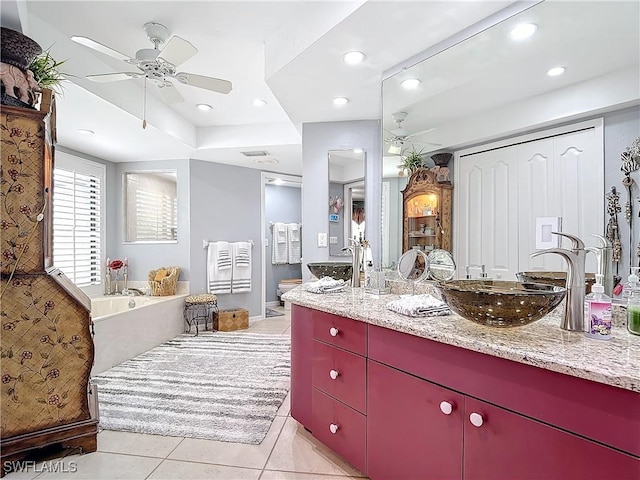 bathroom with ceiling fan, vanity, a tub, and tile patterned floors