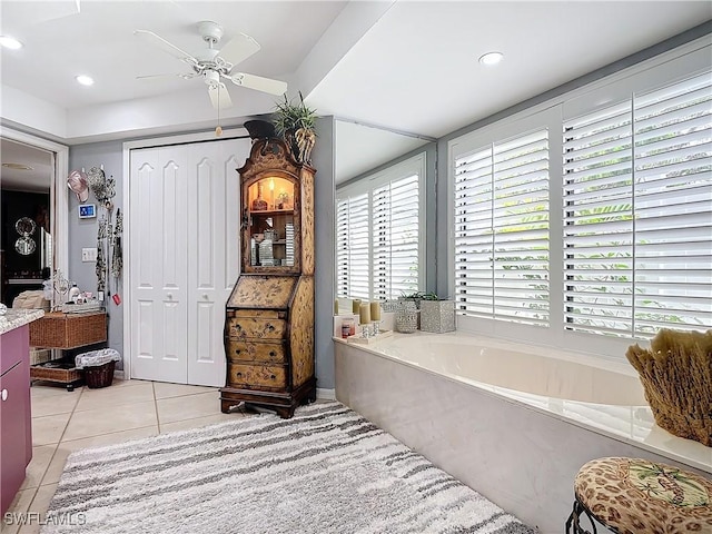 bathroom with ceiling fan, tile patterned flooring, and a bathtub