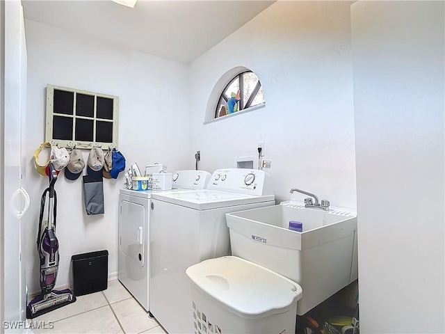 laundry area with light tile patterned flooring, sink, and washing machine and clothes dryer