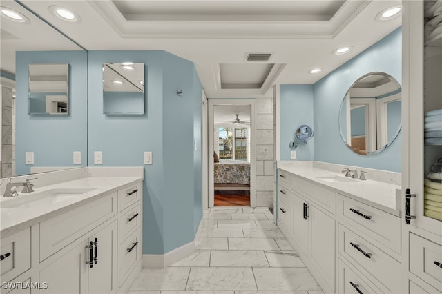 bathroom featuring a raised ceiling, vanity, ceiling fan, and ornamental molding