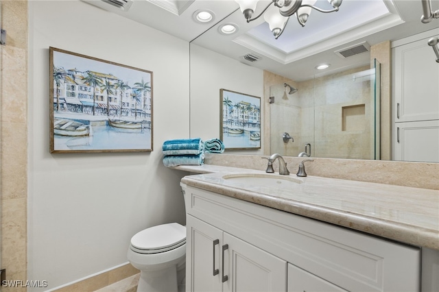 bathroom featuring toilet, an inviting chandelier, a shower with shower door, a tray ceiling, and vanity