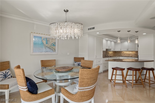 dining room featuring crown molding, sink, and a notable chandelier