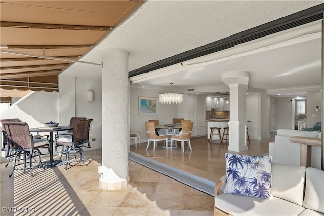 interior space featuring lofted ceiling, light tile patterned flooring, crown molding, and a chandelier