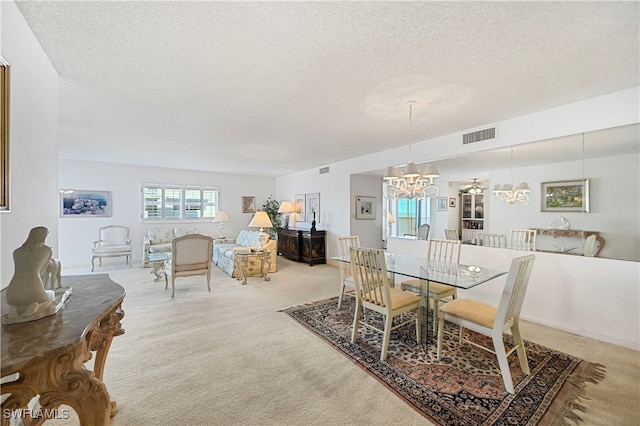 carpeted dining area featuring a textured ceiling and a chandelier