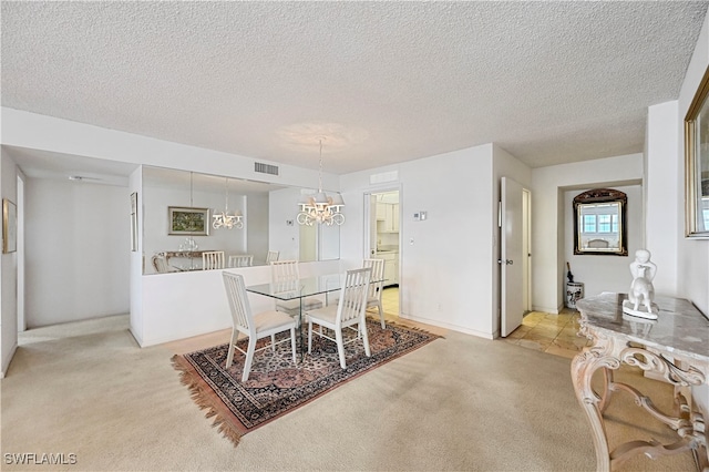 carpeted dining space featuring a textured ceiling and a notable chandelier