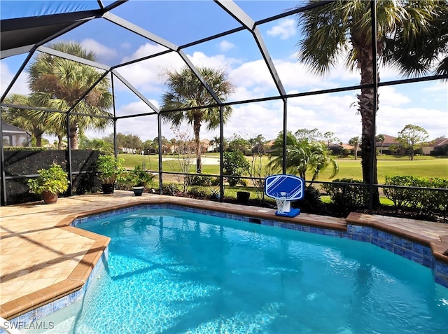 view of pool with glass enclosure and a patio