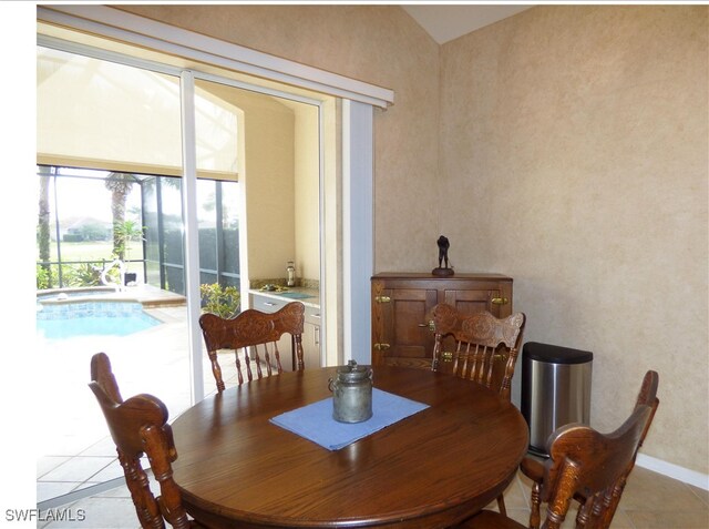 dining area featuring vaulted ceiling and light tile patterned flooring