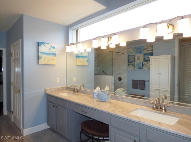 bathroom featuring tiled shower, vanity, and a notable chandelier