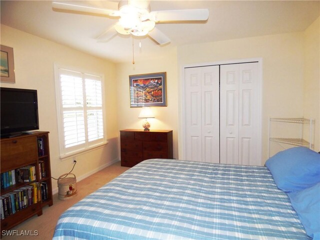 carpeted bedroom featuring ceiling fan and a closet