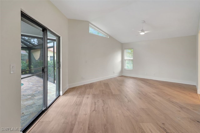 empty room featuring vaulted ceiling, light wood-style flooring, baseboards, and ceiling fan