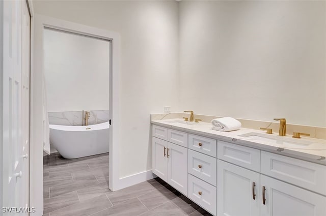 bathroom with tile patterned flooring, a washtub, and vanity