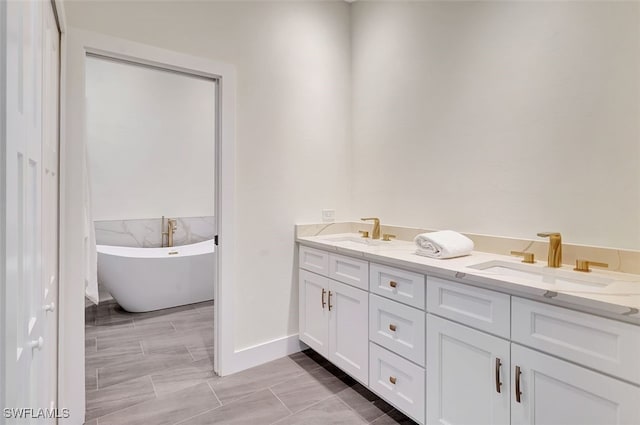 full bathroom featuring double vanity, a freestanding bath, and a sink