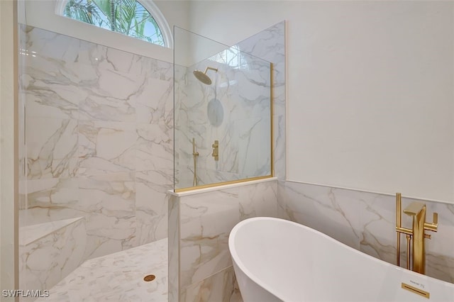 full bathroom featuring a marble finish shower and a freestanding bath