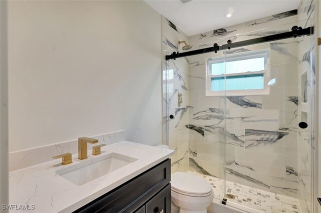 bathroom featuring toilet, vanity, and an enclosed shower