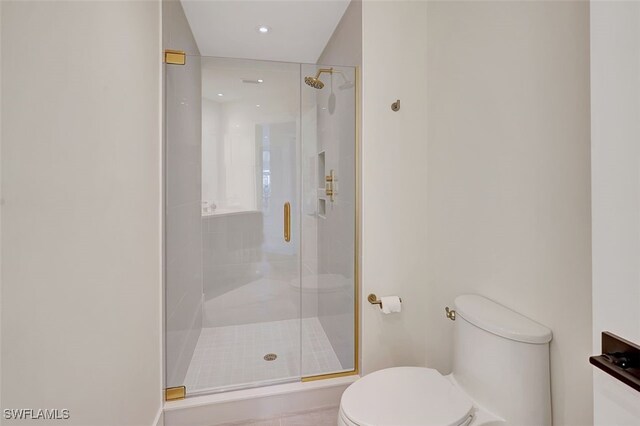 bathroom with toilet and an enclosed shower