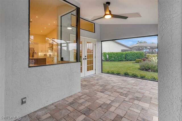 unfurnished sunroom featuring ceiling fan, french doors, vaulted ceiling, and sink