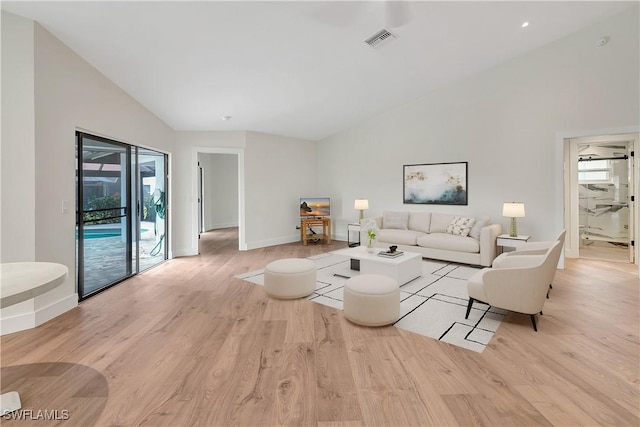 living room with light wood finished floors, visible vents, and a healthy amount of sunlight