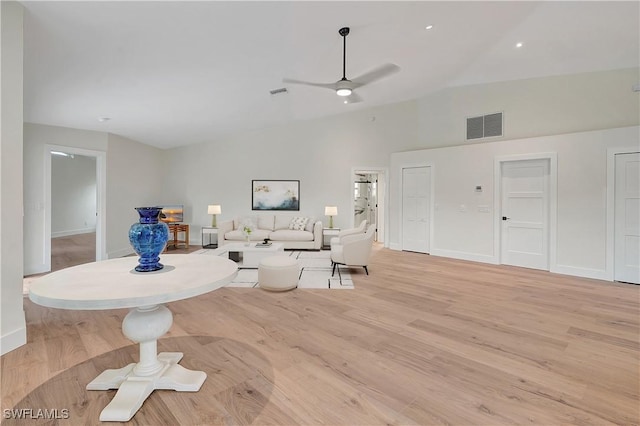 living room featuring ceiling fan, light hardwood / wood-style floors, and lofted ceiling