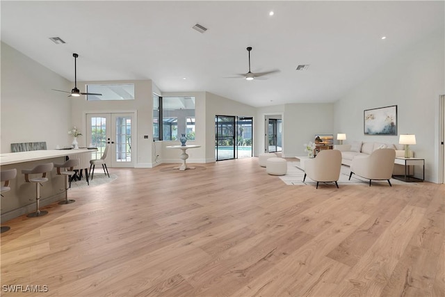 living room with light wood-type flooring, french doors, visible vents, and ceiling fan