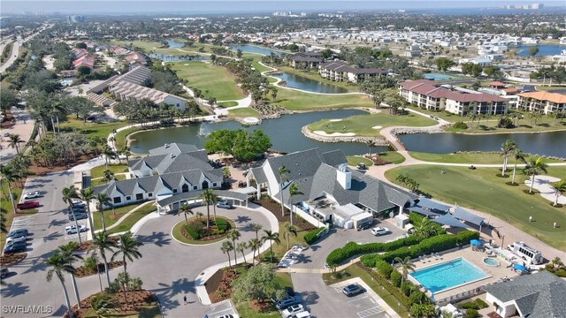 drone / aerial view featuring view of golf course, a water view, and a residential view