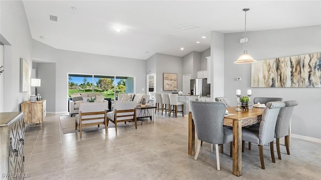 dining room with light tile patterned floors and a towering ceiling