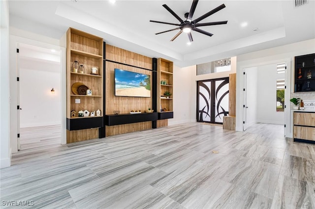 interior space with ceiling fan and a tray ceiling