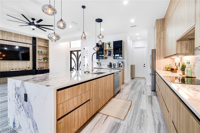 kitchen featuring hanging light fixtures, a large island, light stone counters, and stainless steel appliances