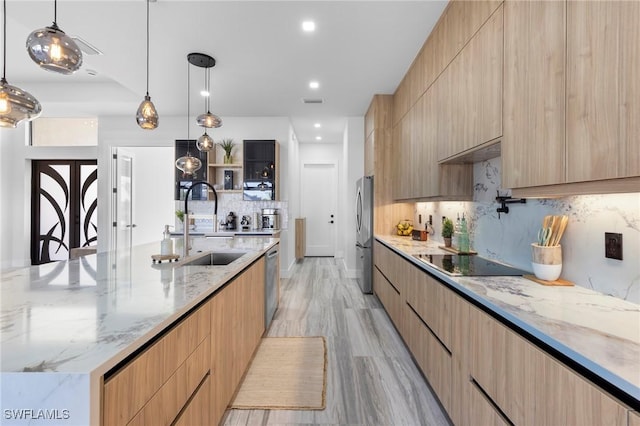 kitchen featuring a spacious island, light brown cabinetry, light stone counters, pendant lighting, and stainless steel appliances