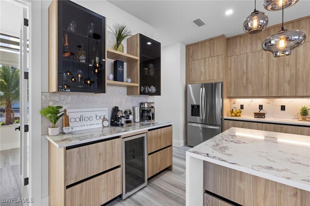 kitchen with light hardwood / wood-style flooring, stainless steel refrigerator with ice dispenser, wine cooler, light stone counters, and decorative light fixtures