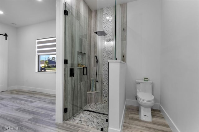 bathroom featuring toilet and a shower with shower door