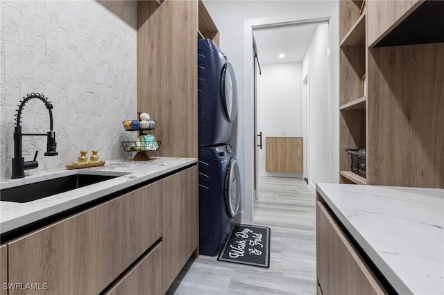 laundry room featuring stacked washer / dryer and sink