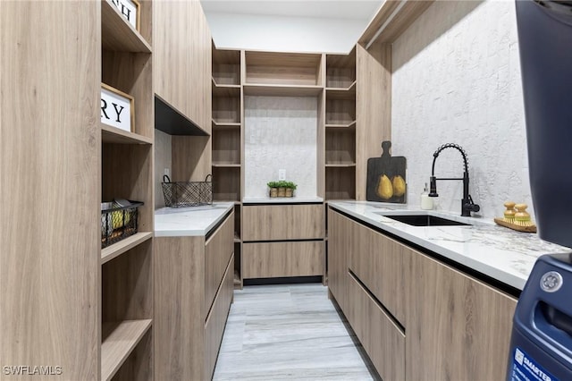 kitchen with light stone counters, sink, and range