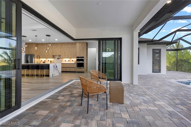 view of patio / terrace featuring sink and glass enclosure