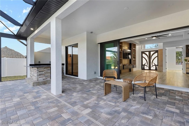 view of patio with ceiling fan and a lanai